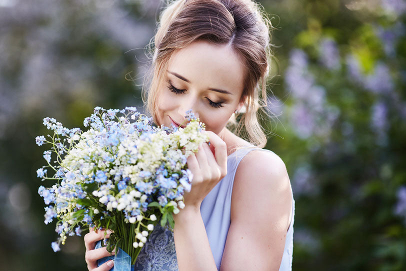 smiling woman smelling bouquet flowers
