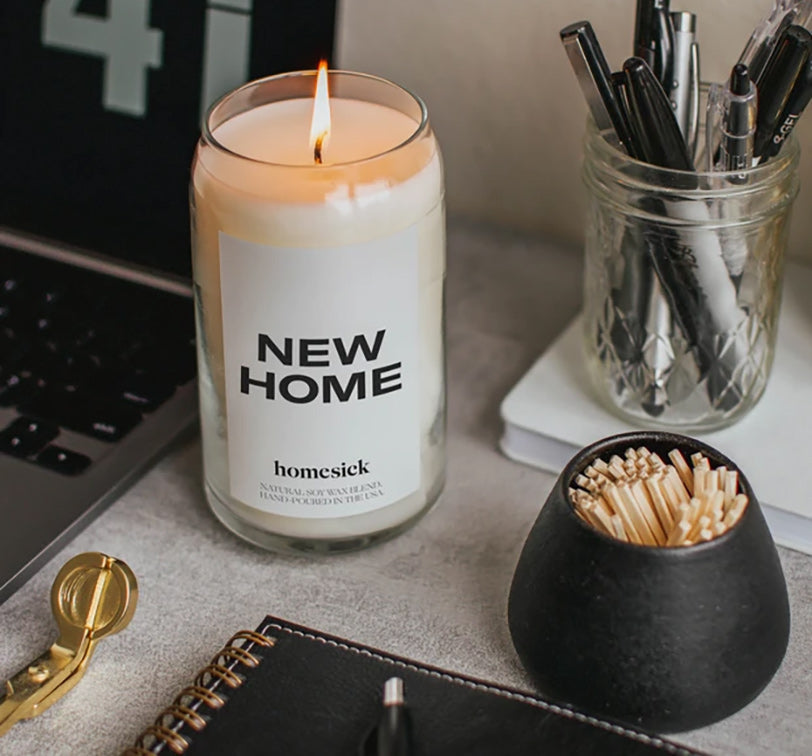 a homesick new home candle next to a jar of matches