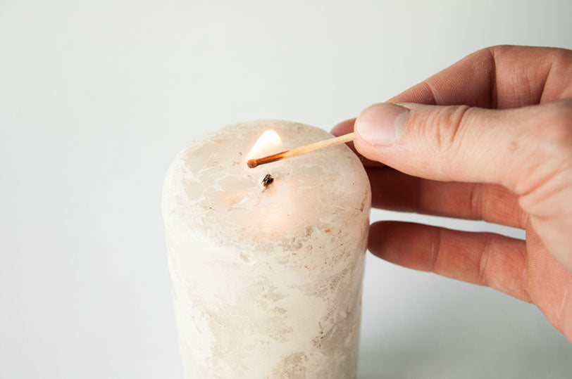 lighting candle with match