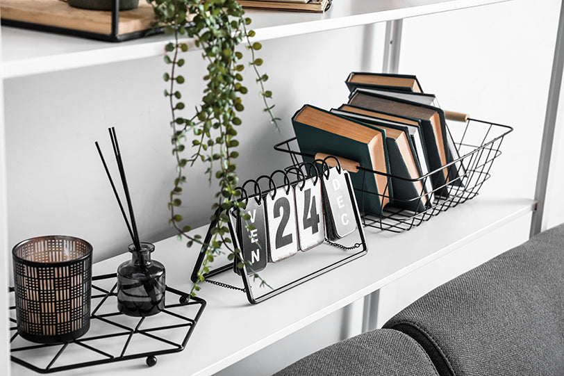 a reed diffuser on a bookshelf next to a calendar