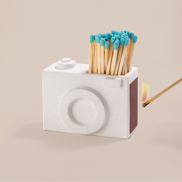 A match holder that is shaped like a mini camera.