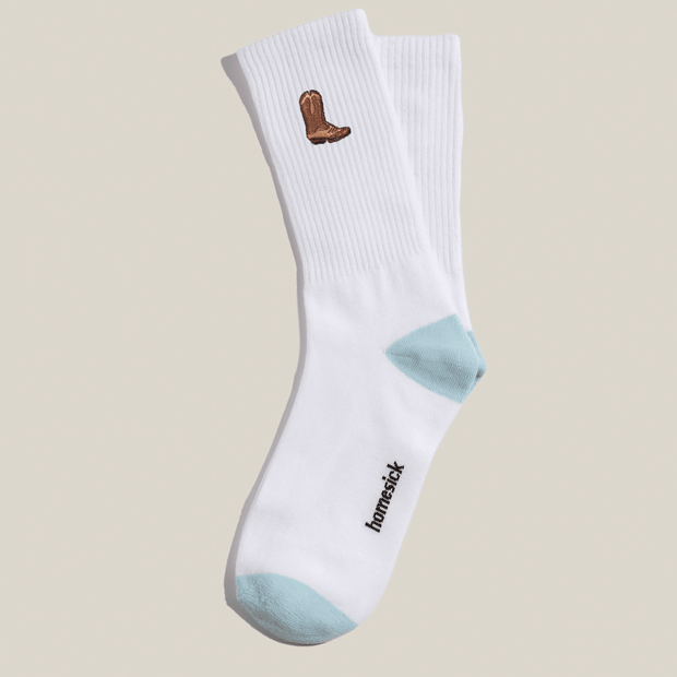 A pair of cotton socks that have a cowboy boot embroidered on the top side calf.
