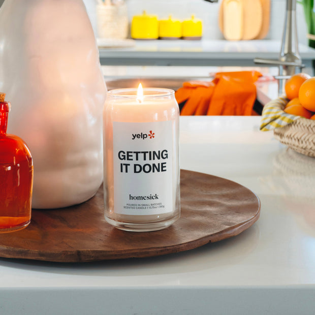 A lit Getting It Done candle in a clean environment