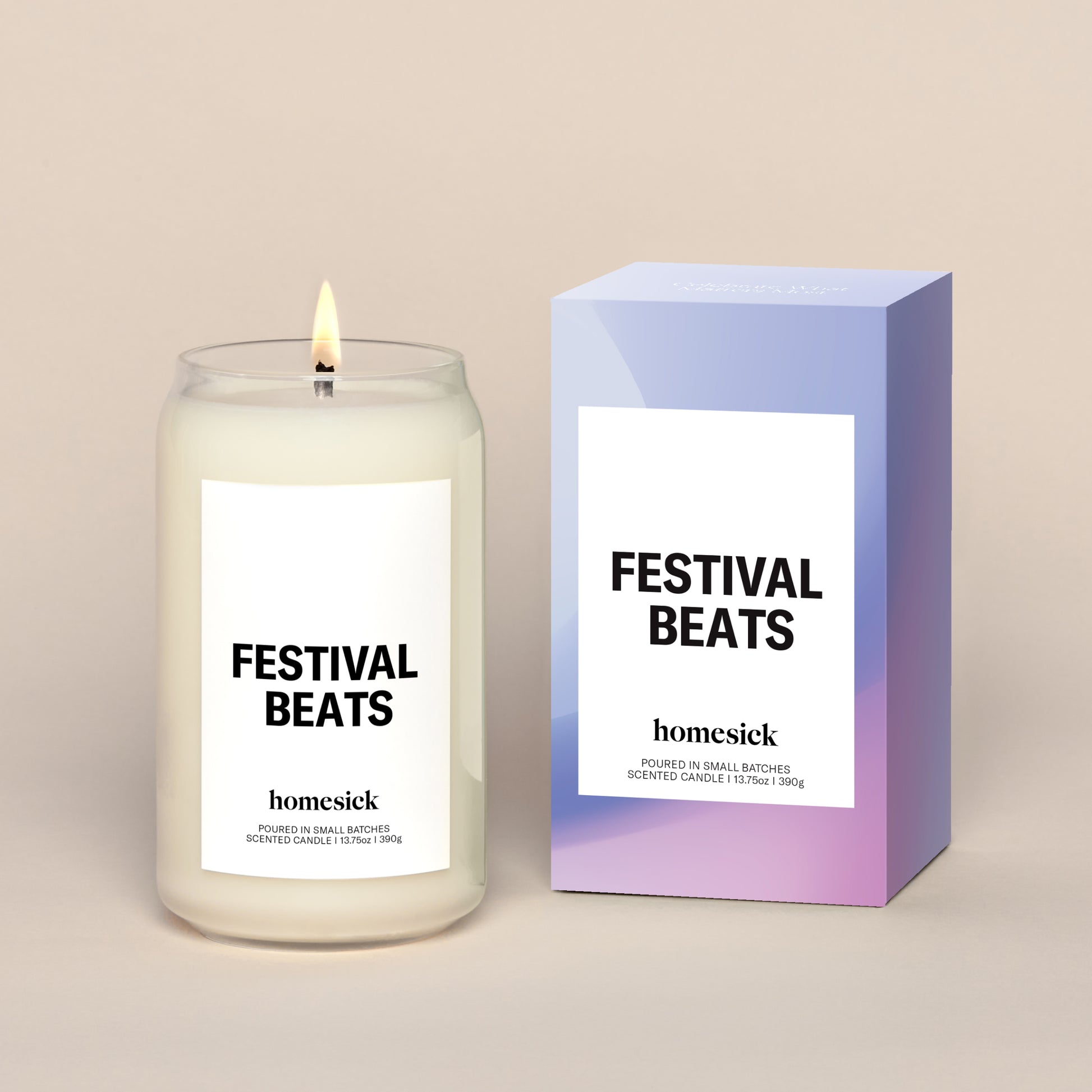 A lit Festival Beats Homesick candle displayed next to its boxed packaging on a dark cream background.