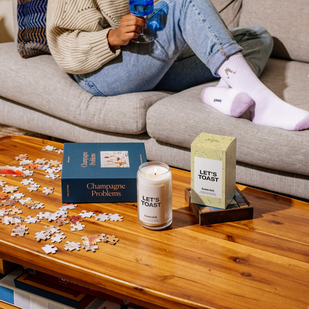 A shot overlooking a living room table with various homesick products displayed out on the table surface.