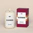 A lit Virginia Tech Blacksburg Homesick candle displayed next to its boxed packaging on a dark cream background.