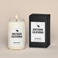 A lit Southern California Homesick candle displayed next to its boxed packaging on a dark cream background.