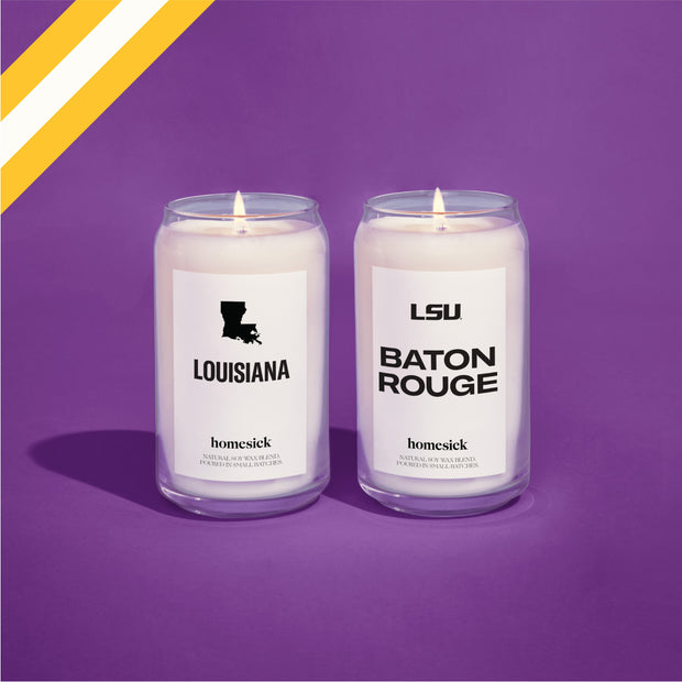 Two Homesick candles shot in a purple studio environment. The two candles are Louisiana and LSU Baton Rouge. In the top left corner is a diagonal graphic of yellow and white.