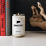 A closeup of the Connecticut candle next to a corner shot of books.