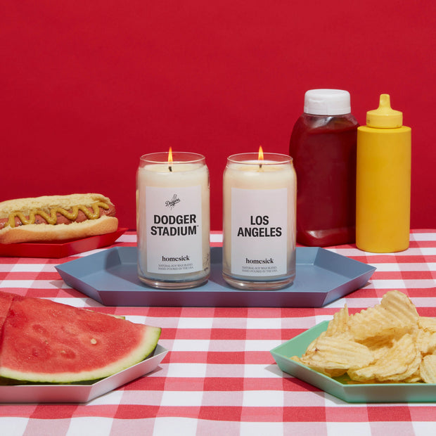 The Dodger Stadium and LA candle side by side amongst a picnic set.