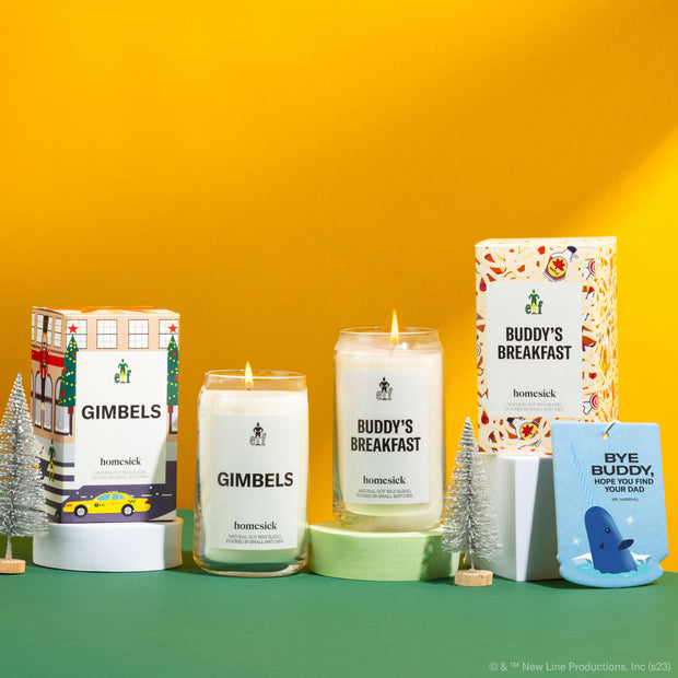 A group shot of all the products available in the Elf x Homesick collaboration. The products are shot on a green surface with a yellow background.