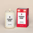 A lit Fenway Park Homesick candle displayed next to its boxed packaging on a dark cream background.