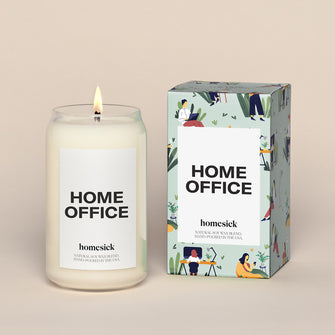 A lit Home Office Homesick candle displayed next to its boxed packaging on a dark cream background.