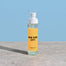 Another product shot of the New York City Room Spray displayed on a smooth concrete surface with a light blue background.