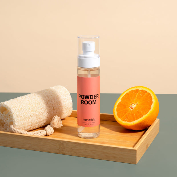 A product shot of the Powder Room Linen spray shot on a dark cream background.