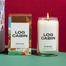 Left to right, is the Log cabins packaging with the candle itself. Shot on a green surface and deep red background.