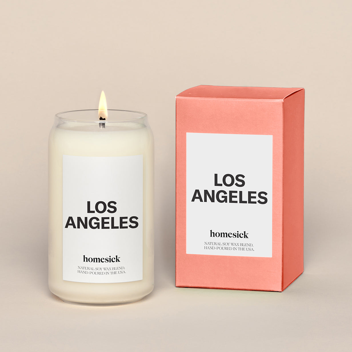 A lit Los Angeles Homesick candle displayed next to its boxed packaging on a dark cream background.