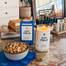 A lifestyle image of the Citi Field candle and its packaging on a red marble counter surface. There are various props around the candle like a bowl of nuts, books, chess set.