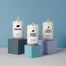 A group product shot of the three Northeast Candles offered at Homesick. Each stand on a cube pedestal that is a different shade of blue. Products are shot in a light blue studio environment.