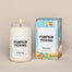 A lit Pumpkin Picking Homesick candle displayed next to its boxed packaging on a dark cream background.