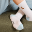 A close up image of a model wearing the high rise socks that have a cowboy icon on the side calf