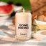 A close up of the Gone Hiking candle. The background is blurred but one can decipher a picnic. 