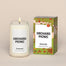 A lit Orchard Picnic Homesick candle displayed next to its boxed packaging on a dark cream background.