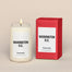A lit Washington, D.C.  Homesick candle displayed next to its boxed packaging on a dark cream background.